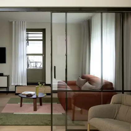 a glass door with a couch and a table in front of it