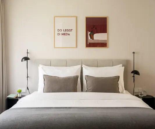 a bed with pillows and two framed pictures above it