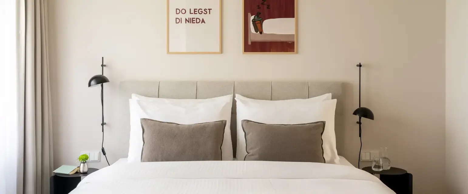 a bed with pillows and two framed pictures above it