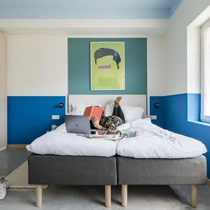 a person lying on a bed with a laptop