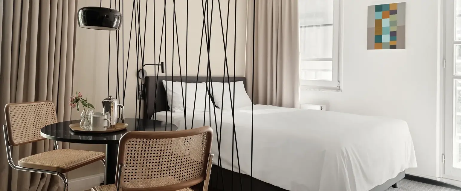 a room with a bed and chairs