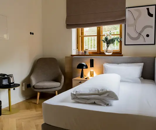 a bed with a lamp and a chair in a room