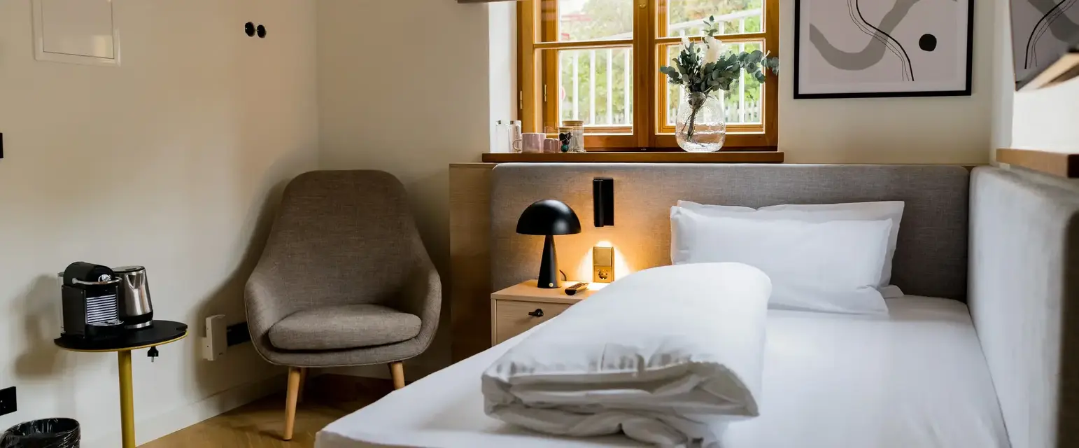 a bed with a lamp and a chair in a room