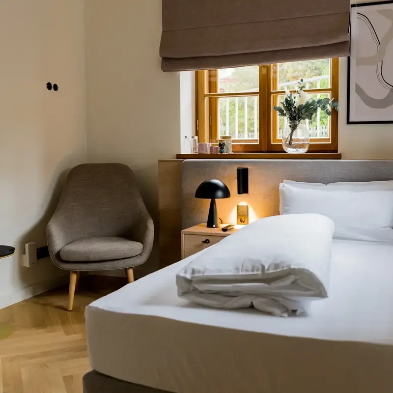 a bed with a lamp and a chair in a room