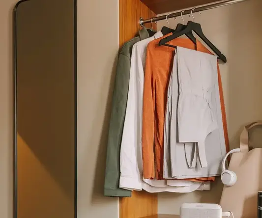 a closet with clothes and a mirror