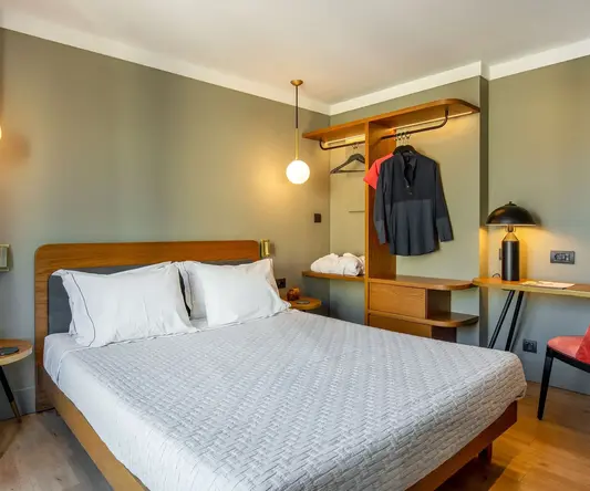 a bed with white sheets and a wooden headboard