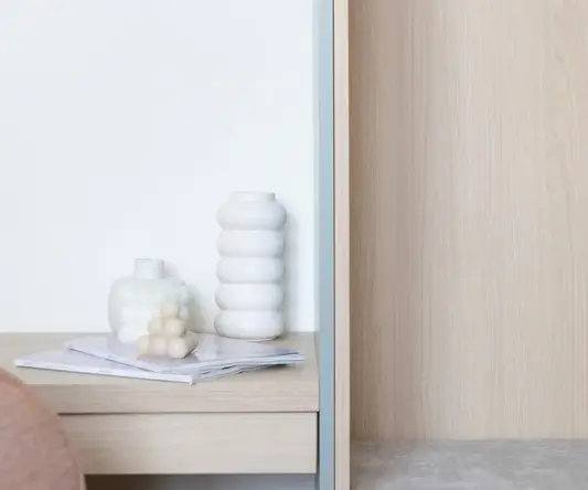 a white vases on a book on a table