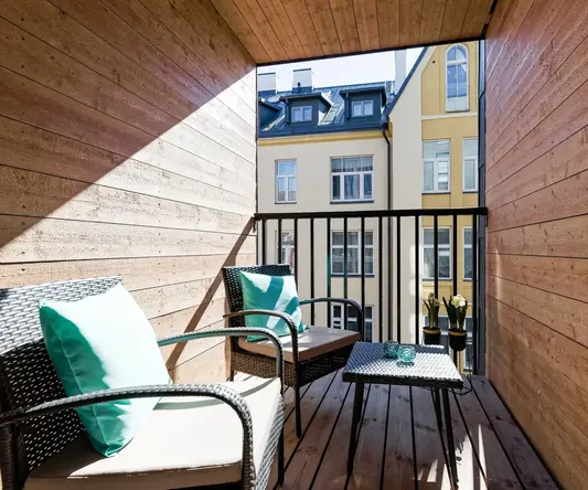 a balcony with chairs and a table