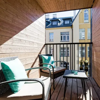 a balcony with chairs and a table