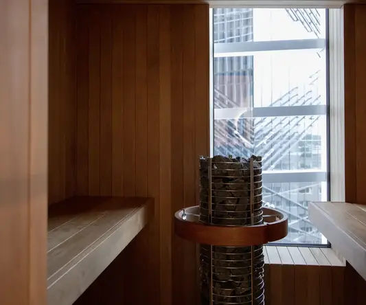 a room with a wood wall and a metal basket with rocks