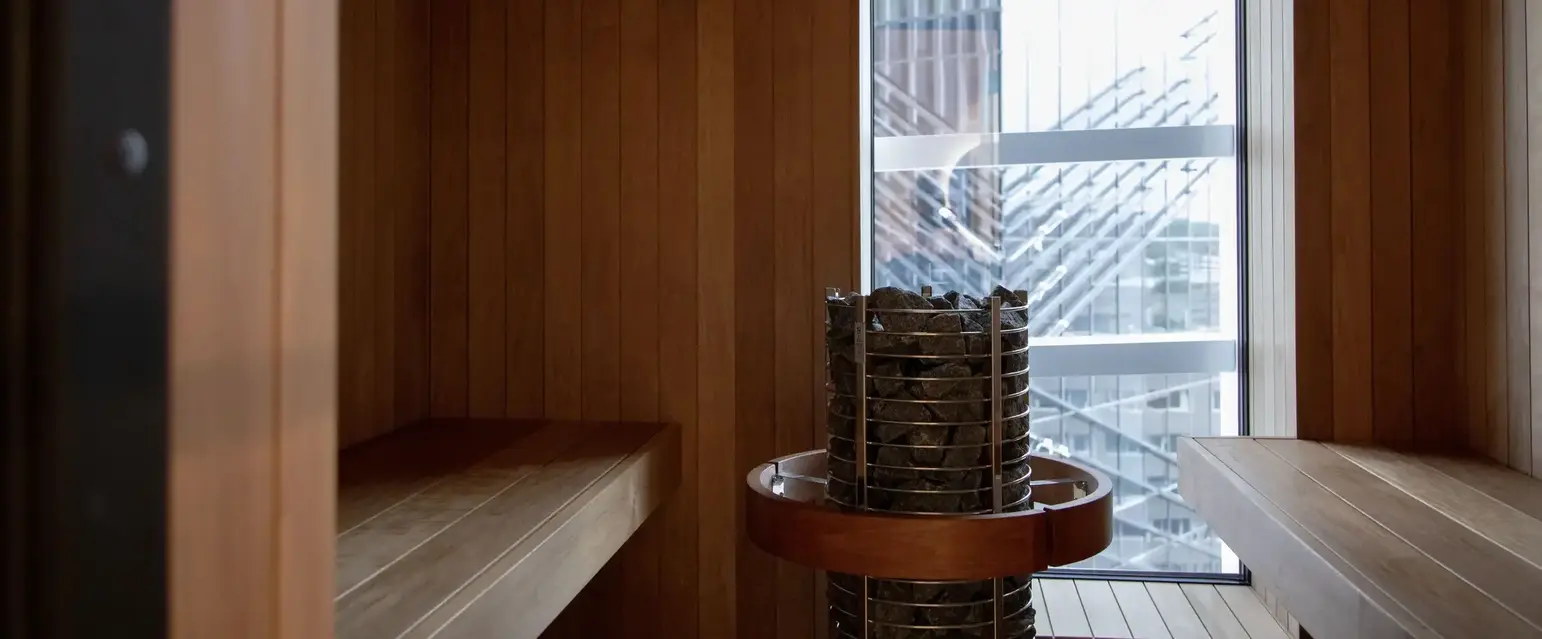 a room with a wood wall and a metal basket with rocks