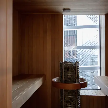 a room with a wood wall and a metal basket with rocks