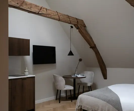 a room with a bed and a table and chairs