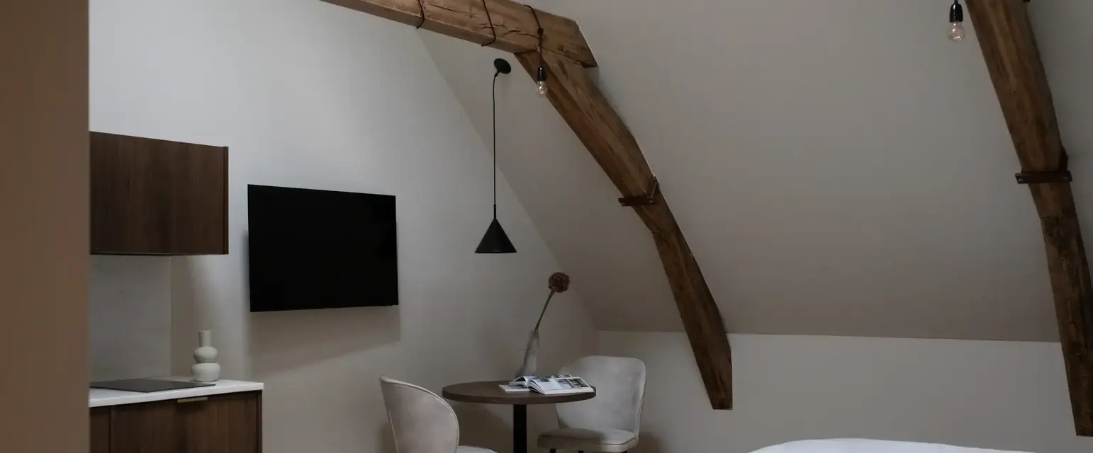 a room with a bed and a table and chairs