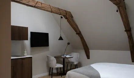 a room with a bed and a table and chairs