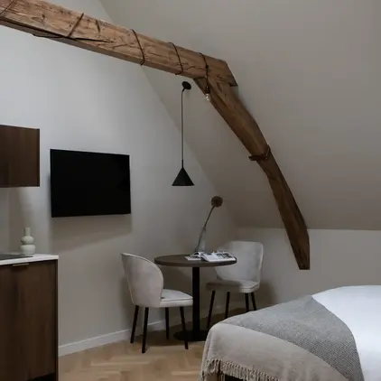 a room with a bed and a table and chairs