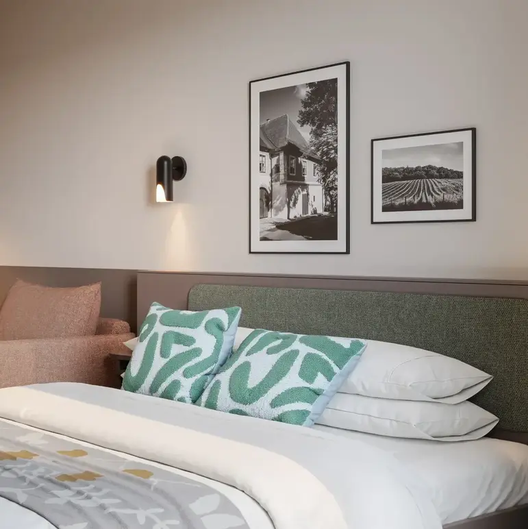a bed with pillows and a chair in a room