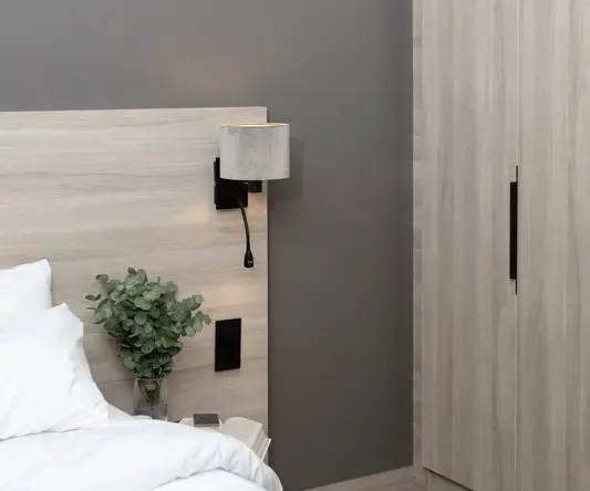 a bed with a plant on the side