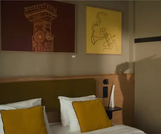 a bed with pillows and a painting on the wall