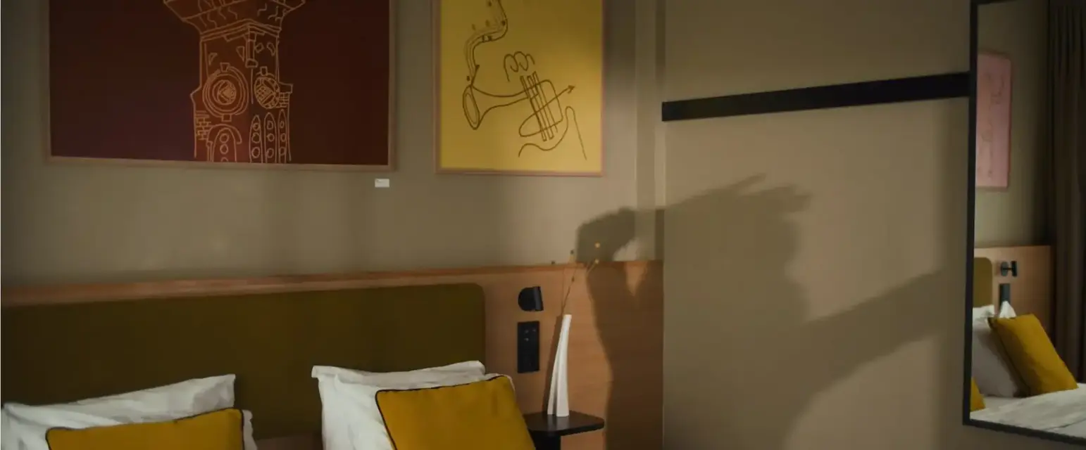 a bed with pillows and a painting on the wall