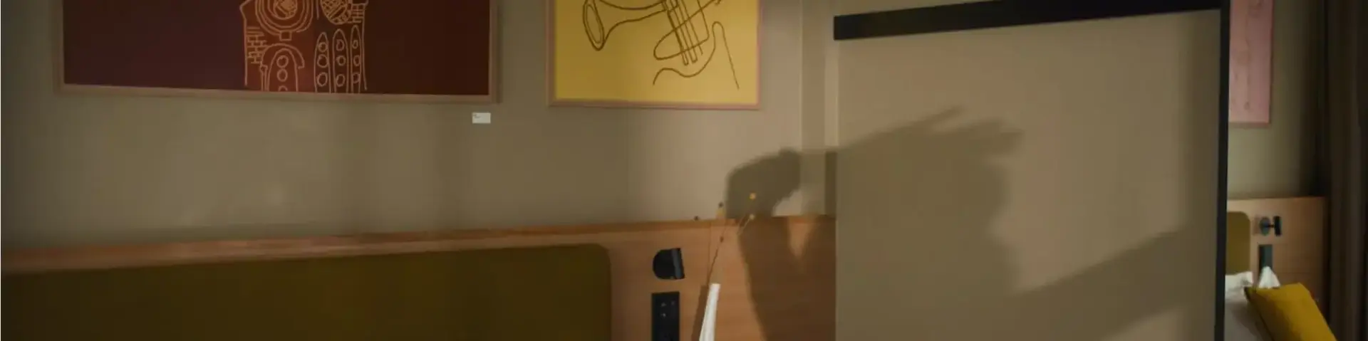 a bed with pillows and a painting on the wall