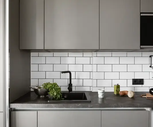 a kitchen with grey cabinets and a sink