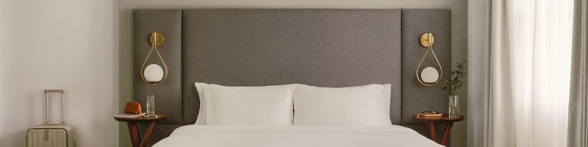 a bed with a headboard and a lamp