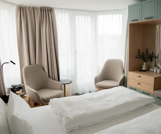 a room with a bed and chairs