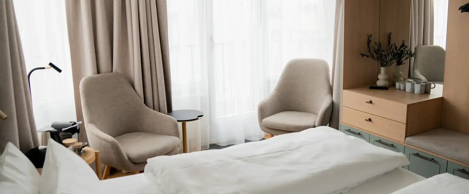 a room with a bed and chairs