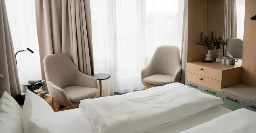 a room with a bed and chairs