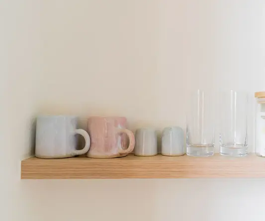 a shelf with cups and glasses