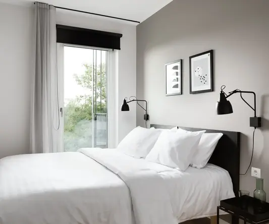 a bed with white sheets and pillows