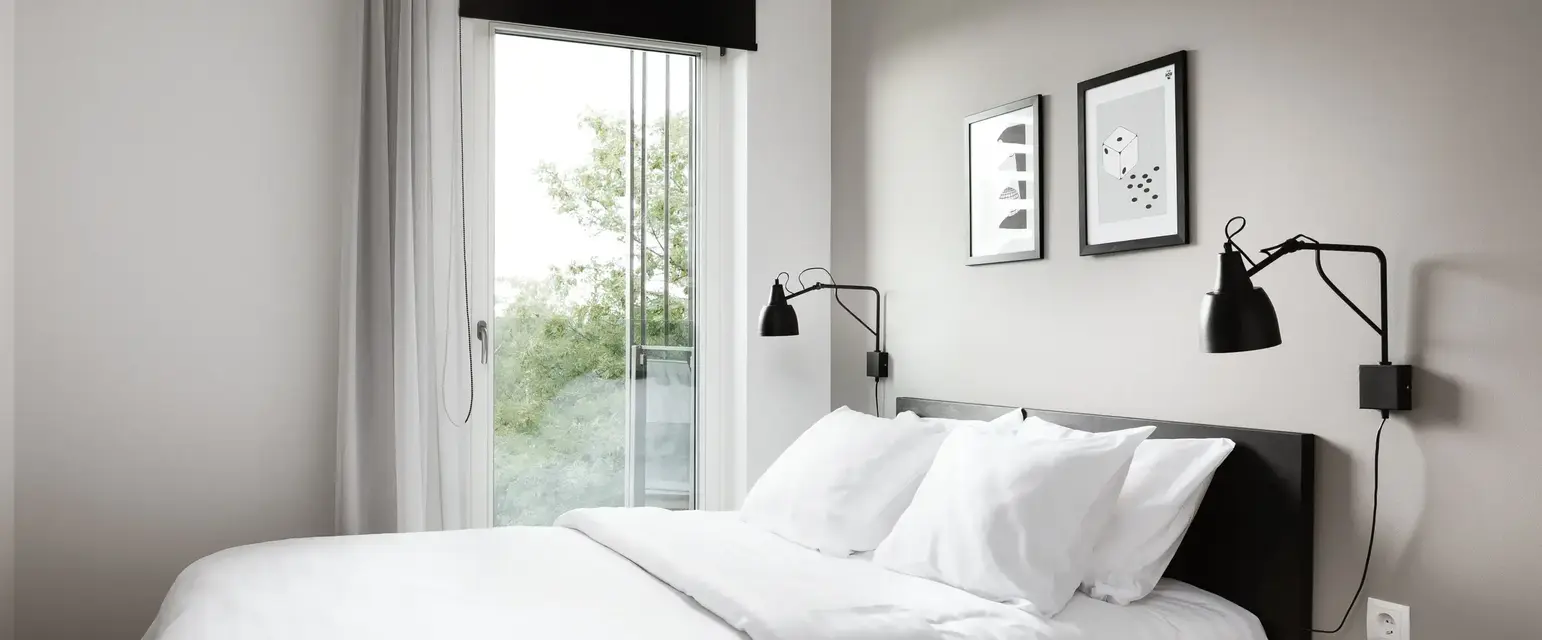 a bed with white sheets and pillows