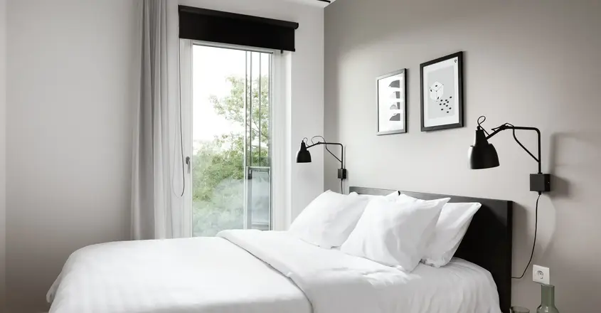 a bed with white sheets and pillows