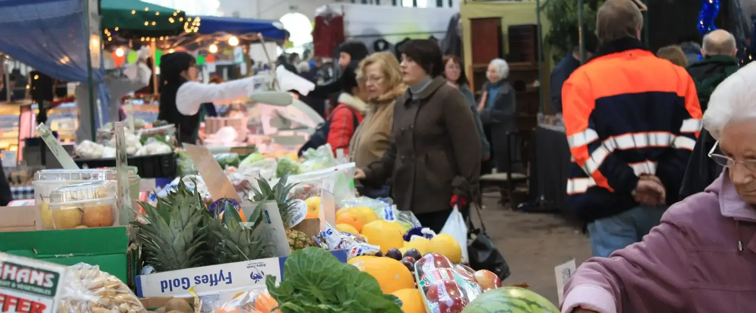 people at a market with many fruits