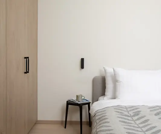 a bed with pillows and a small table