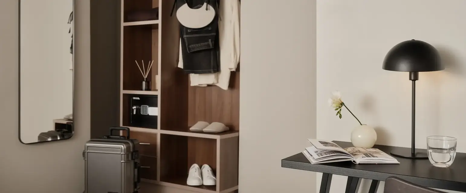 a room with a desk and a chair and a table with a suitcase