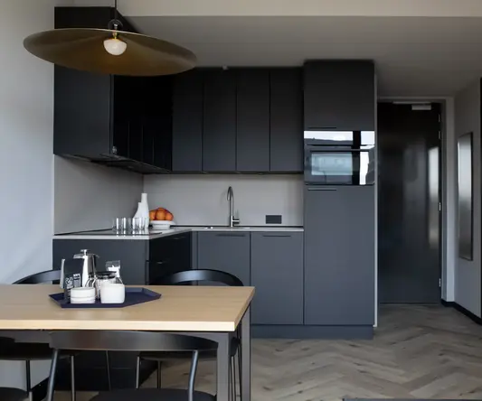 a kitchen with black cabinets and a table