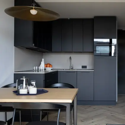 a kitchen with black cabinets and a table