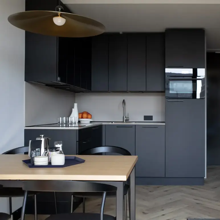 a kitchen with black cabinets and a table