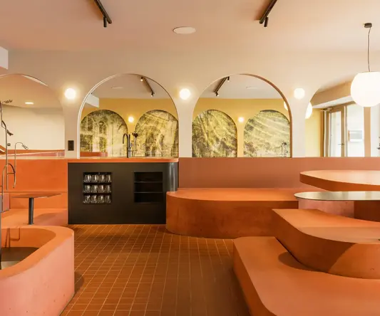 a room with orange benches and a black counter