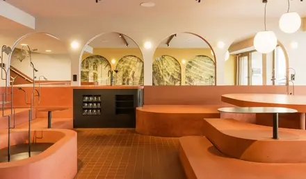 a room with orange benches and a black counter
