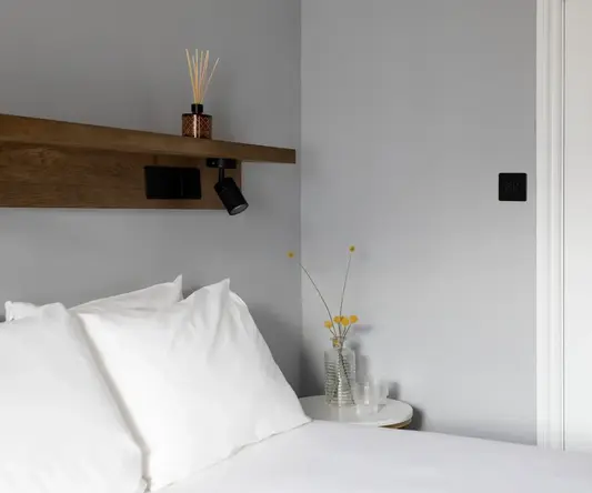 a bed with white sheets and pillows