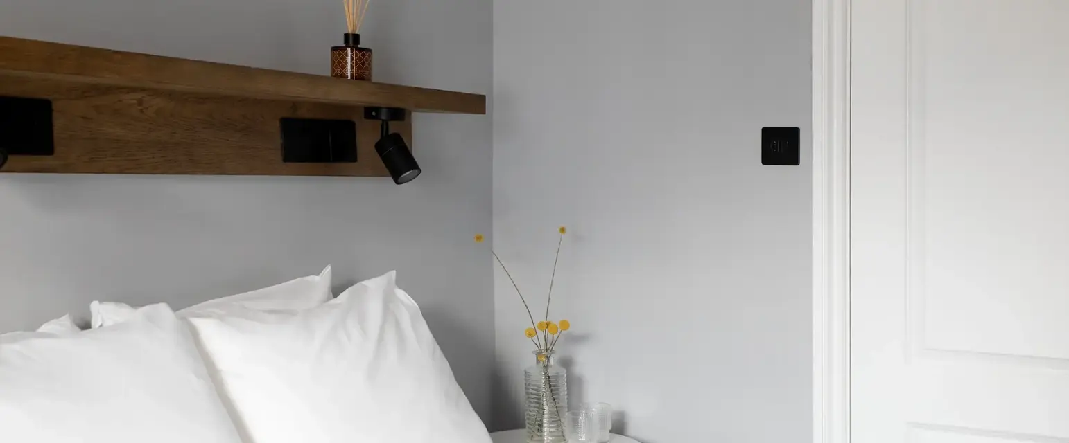 a bed with white sheets and pillows