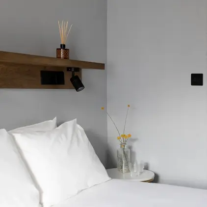 a bed with white sheets and pillows