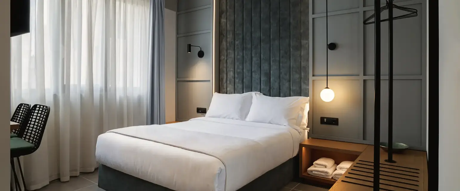 a bed with a lamp and a shelf in a room