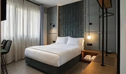 a bed with a lamp and a shelf in a room