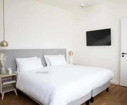 a bed with a tv on the wall