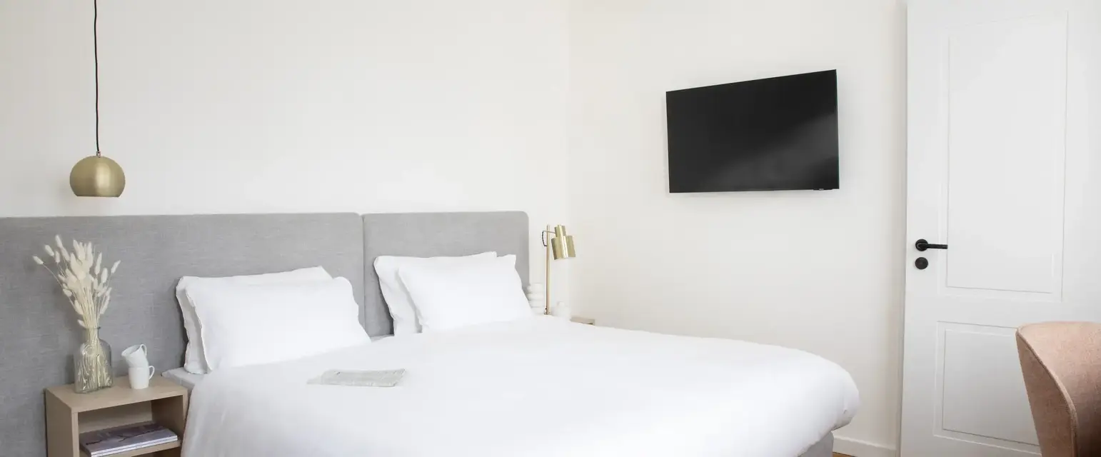 a bed with a tv on the wall