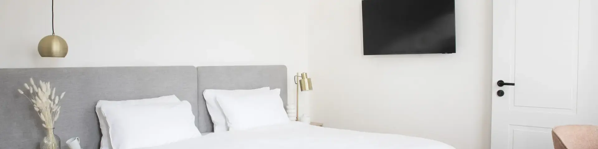 a bed with a tv on the wall